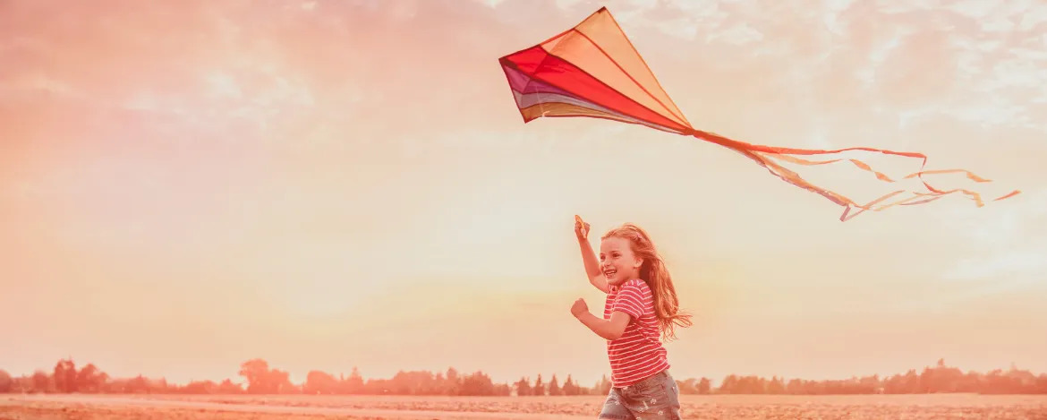 child running flying kite