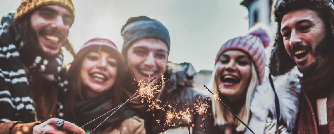 Close up image of happy friends enjoying out with sparklers - Group of young people celebrating new year eve with fireworks - Holidays and friendship concept